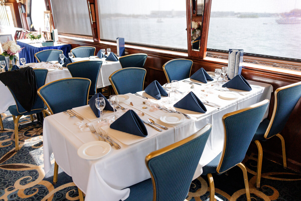 Intimate yacht wedding reception with elegant white flowers, candles, and coastal-inspired décor in St. Petersburg, Florida.