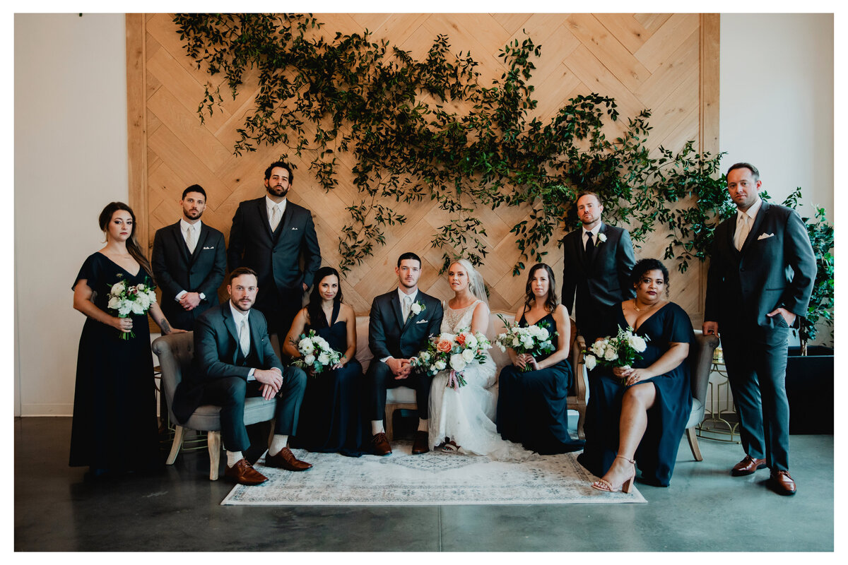 bridal party in front of herringbone wall
