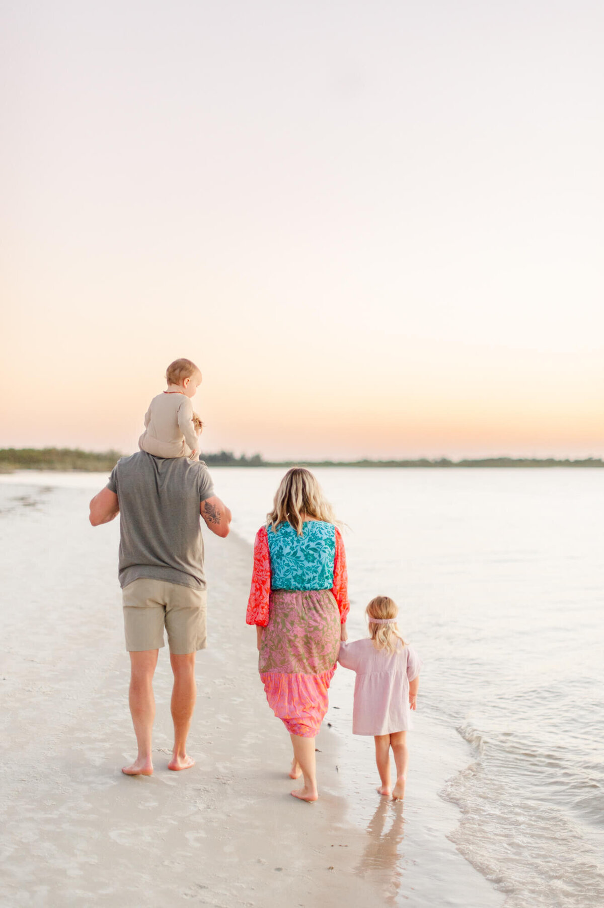 Beautiful sunset image of family walking near the shoreline at New Smryna Dunes Park