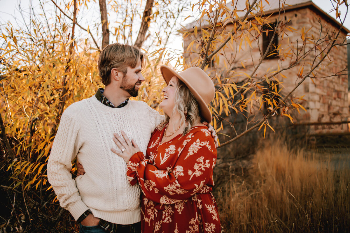 colorado couple embrace in wheat field in thornton colorado for engagement photos