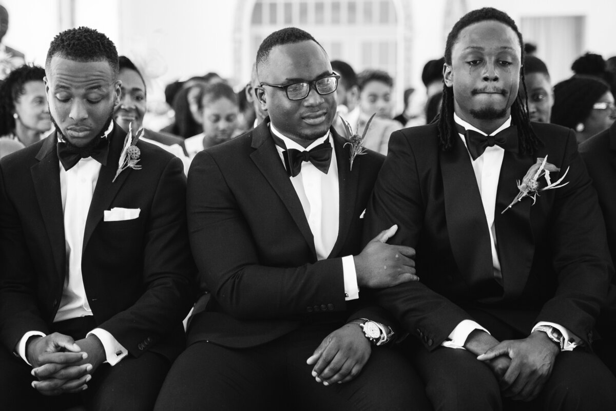 groomsmen holding groom whilst he cried during the ceremony