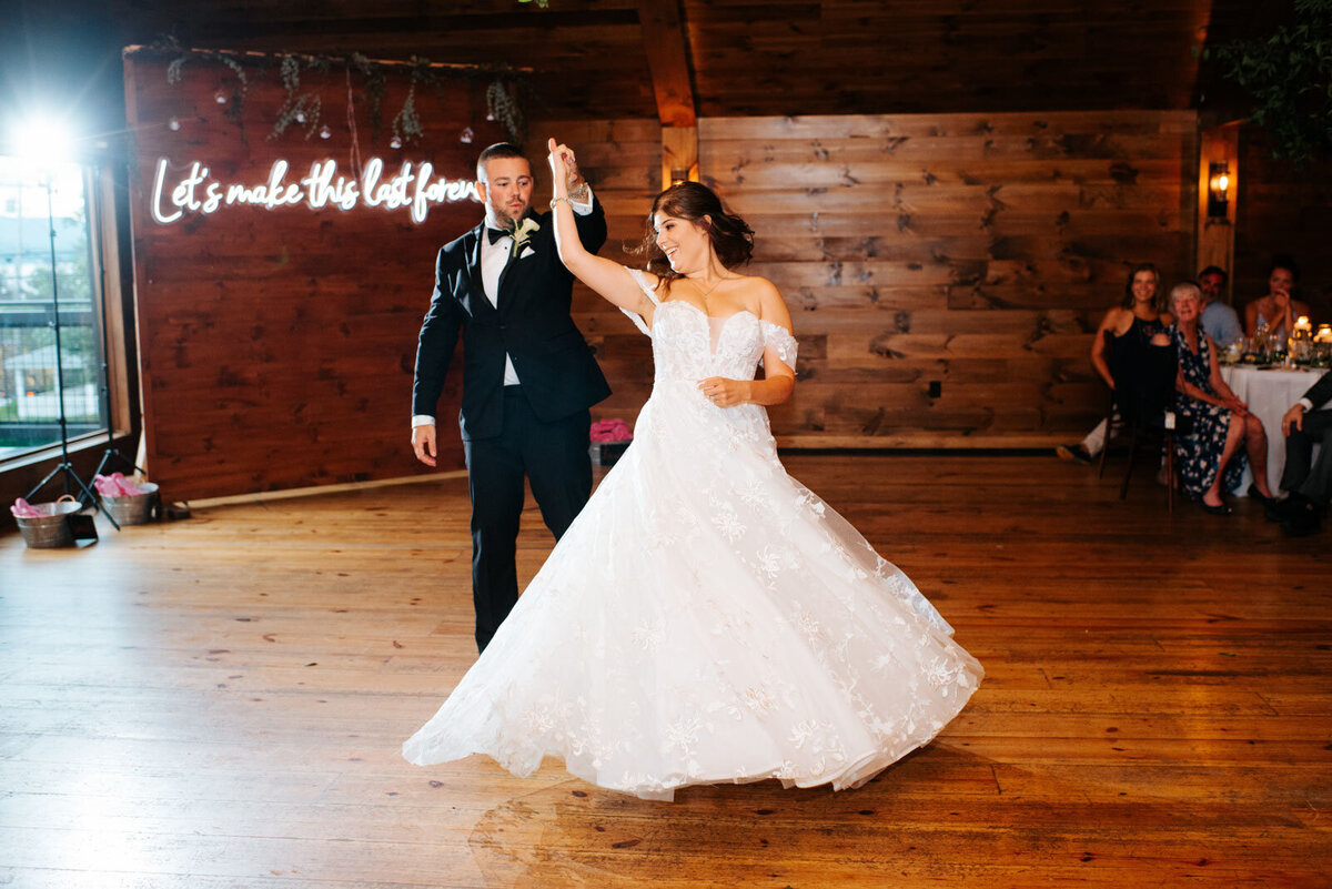 groom twirling bride on dance floor at lake bomoseen lodge wedding reception