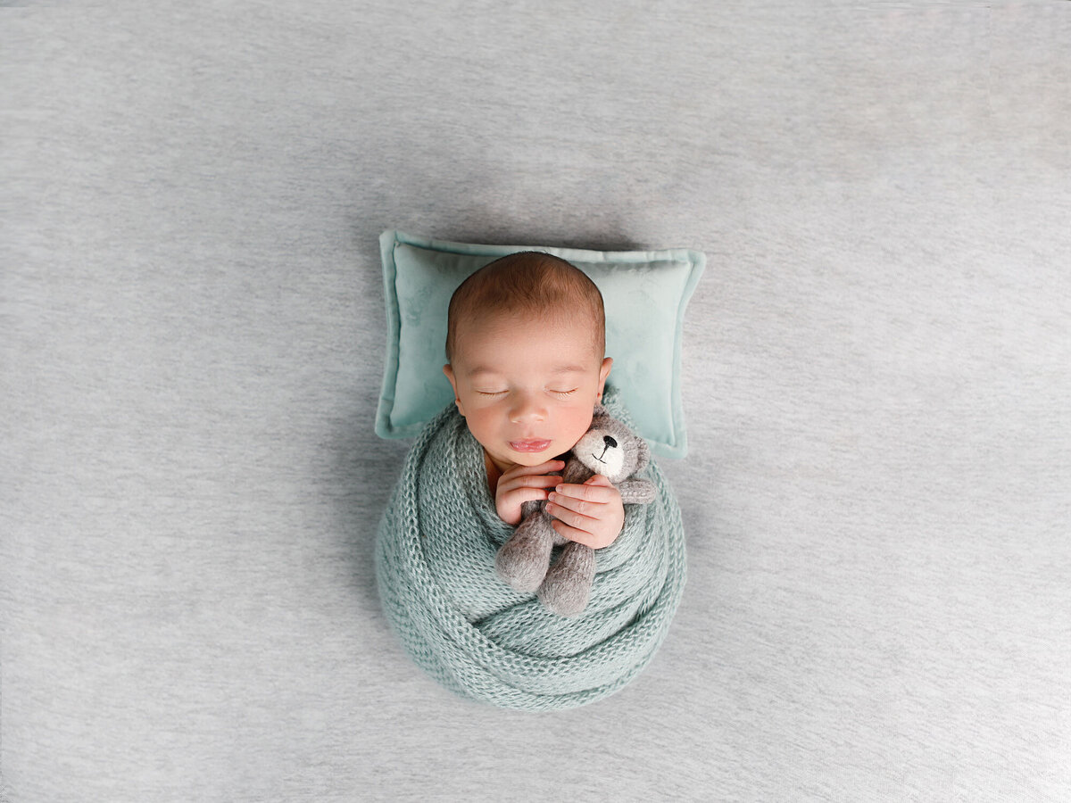 Newborn-photography-session-newborn-in-green-wrap-with-hat,-photo-taken-by-Janina-Botha-photographer-in-Oakville-Ontario