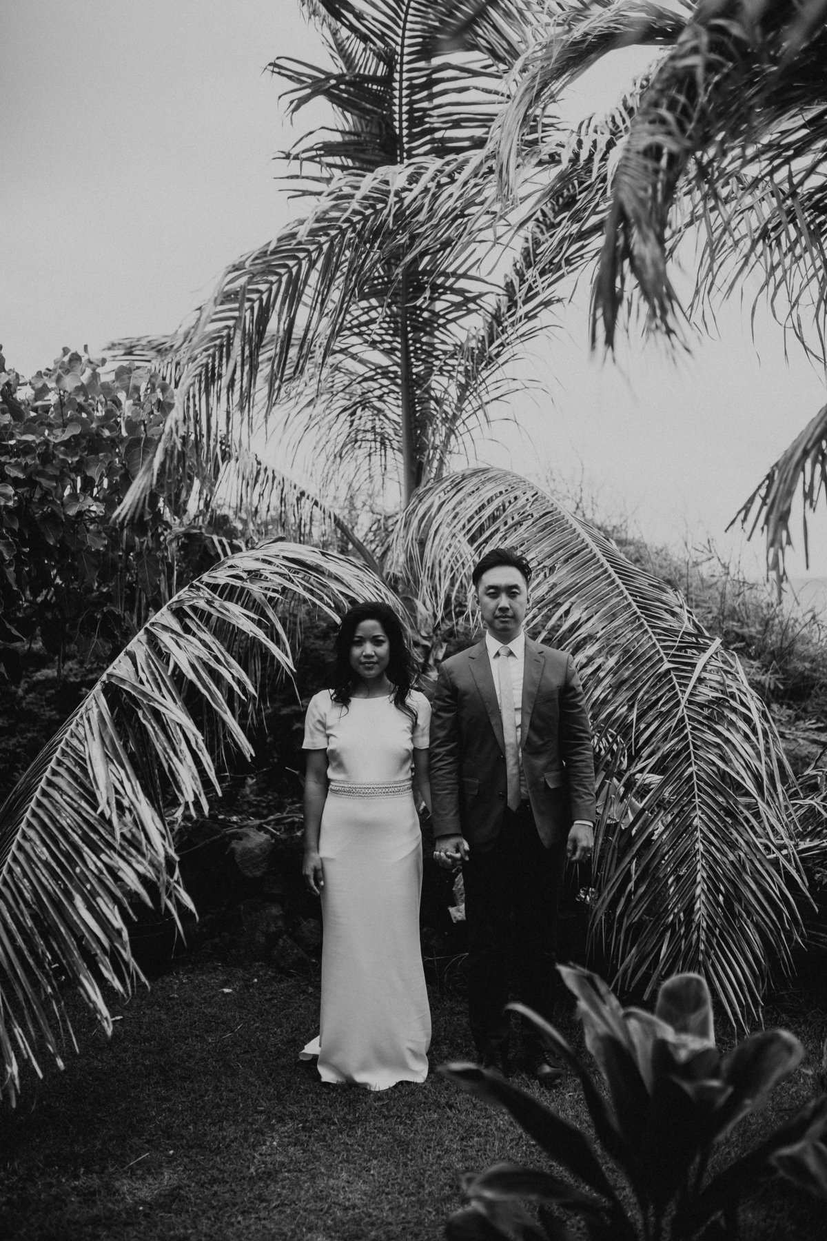 bride and groom in hawaii looking at camera