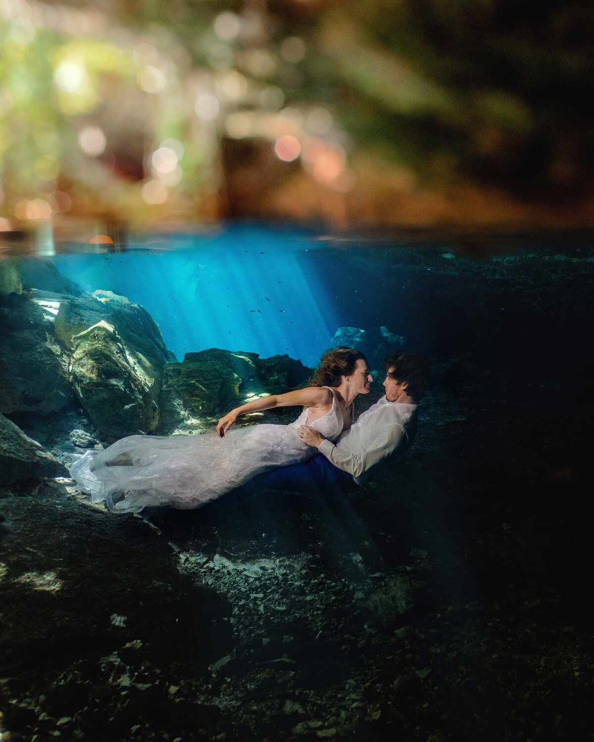 Bride laying on Groom in underwater TTD in Riviera Maya Mexico