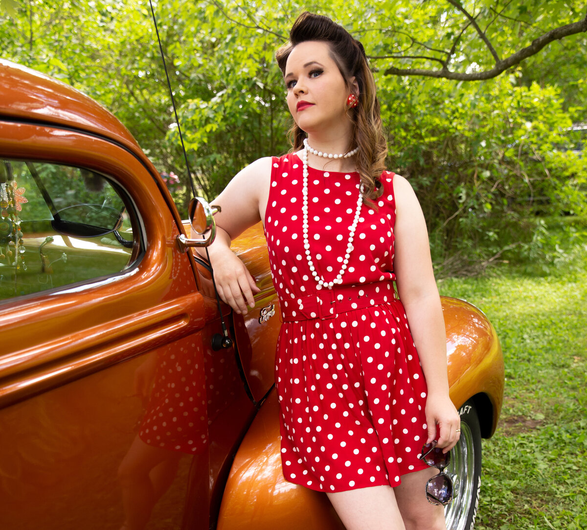 goddess studio boudoir woman red with white polka dots white beads leaning on old ford pickup sunglasses in hand