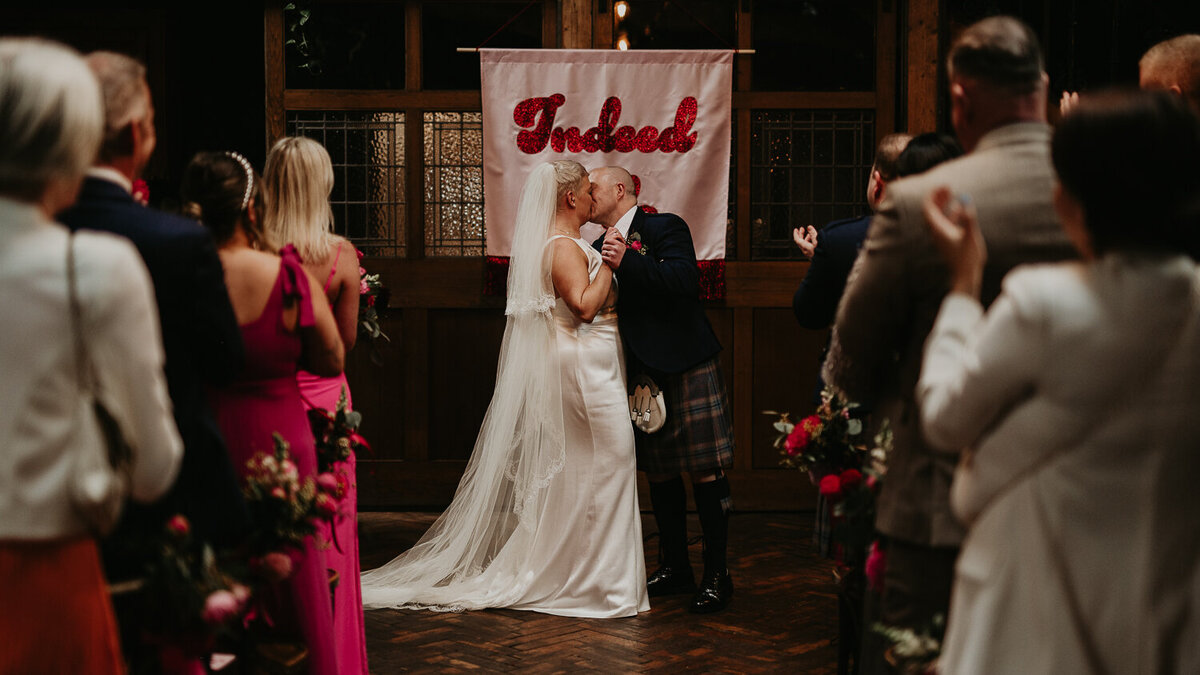 A bride and groom share their first kiss at Clapton Country Club in London.