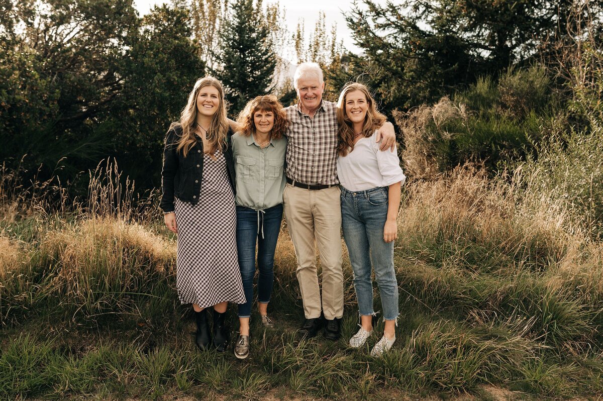 family adult kids te anau new zealand portraits together summer long grass sunset