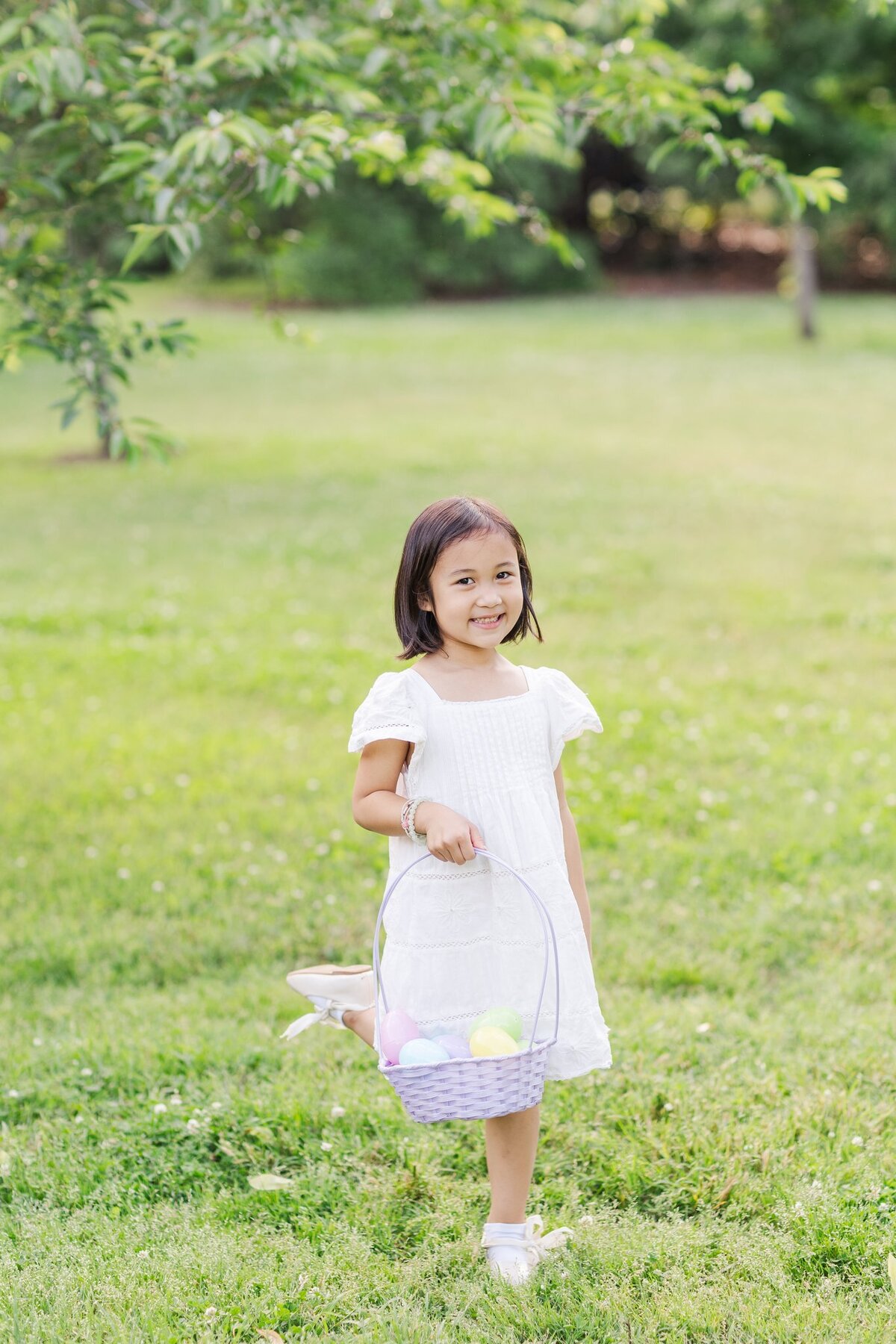 Little girl holds Easter basket and smiles during spring in Nashville, TN
