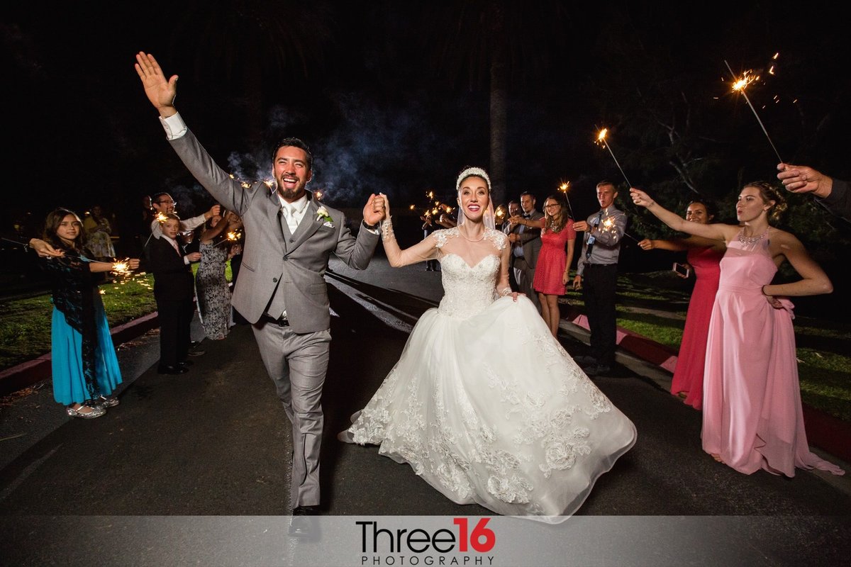 Bride and Groom exit the reception to waiting guests with sparklers