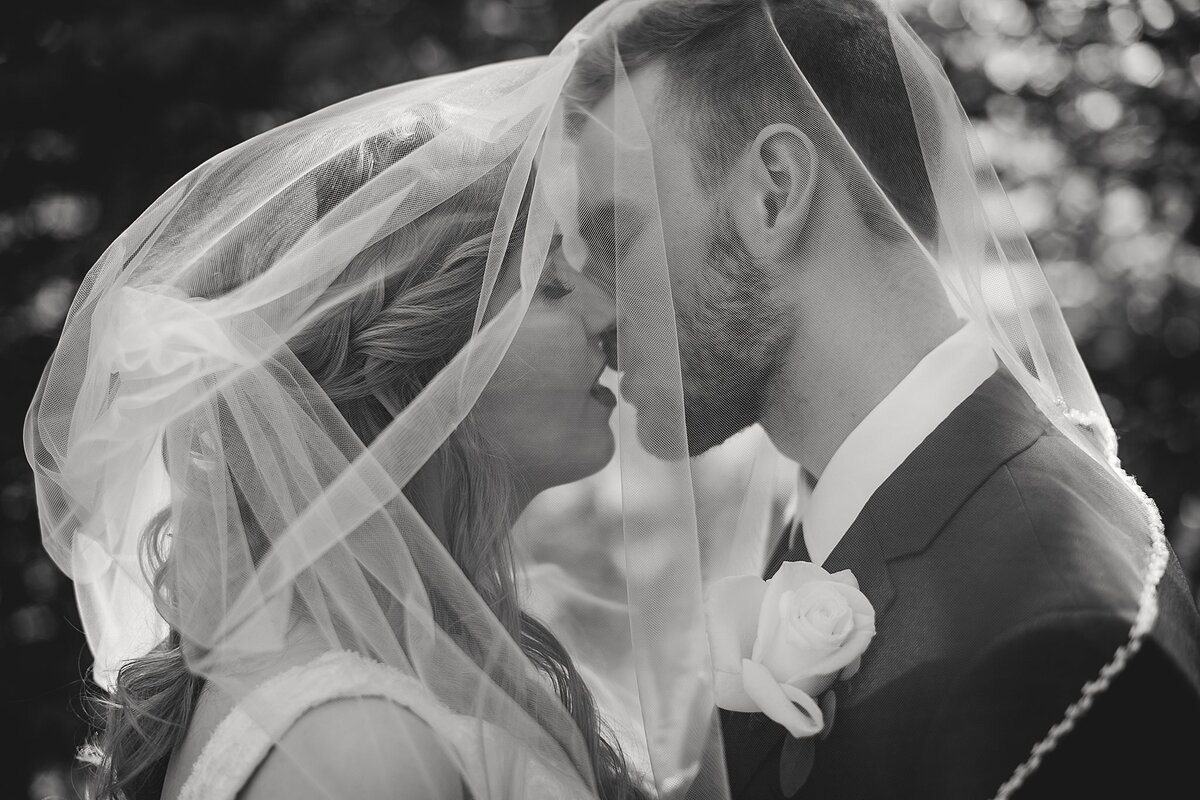 black and white images of couple kissing under veil