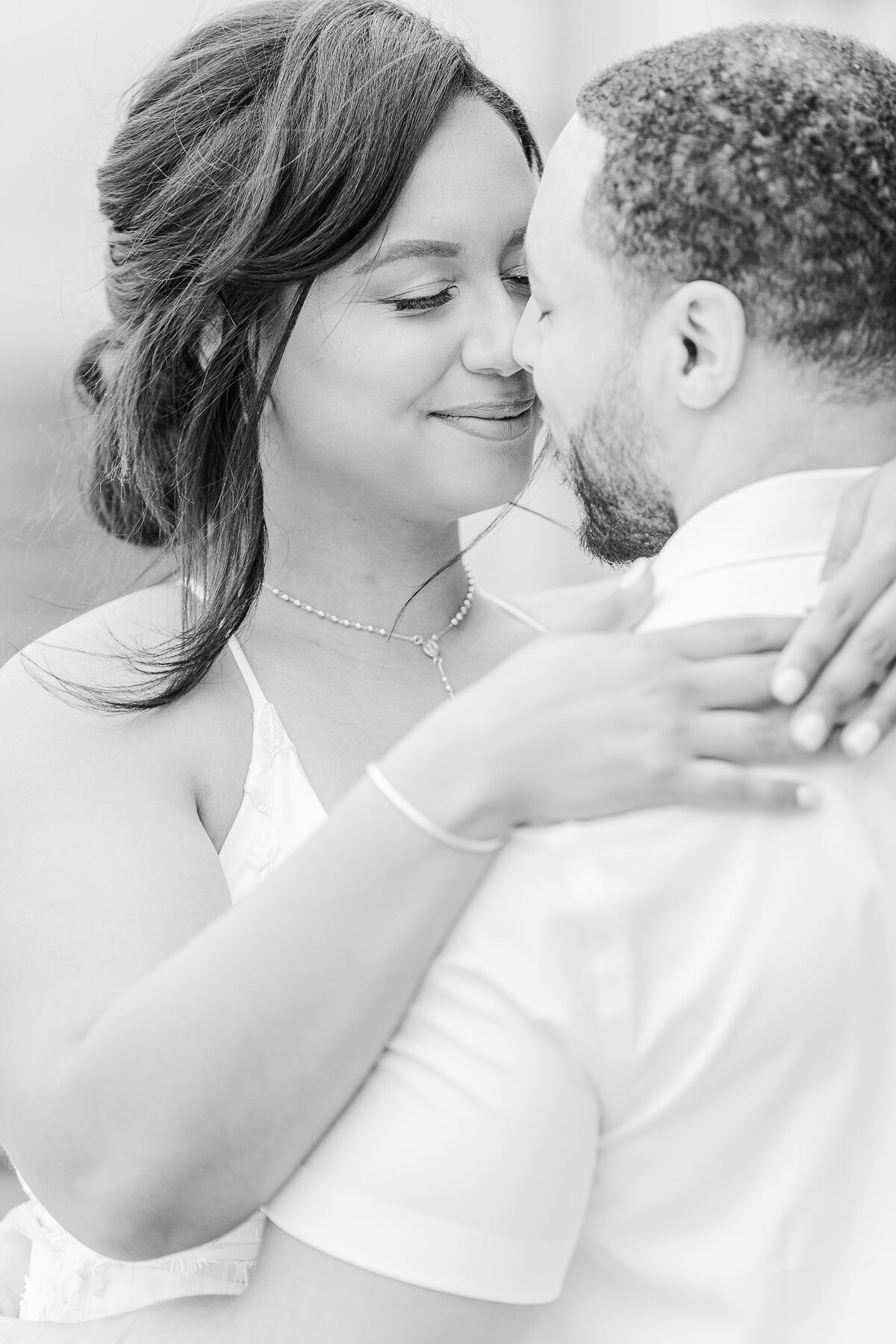 Close Up Image. Man and woman  share an embrace at their Crane Estate Wedding in Ipswich, MA. The image features the woman's face and the grooms's side profile. Their noses are touching and about to kiss. Captured by MA wedding photographer Lia Rose Weddings.
