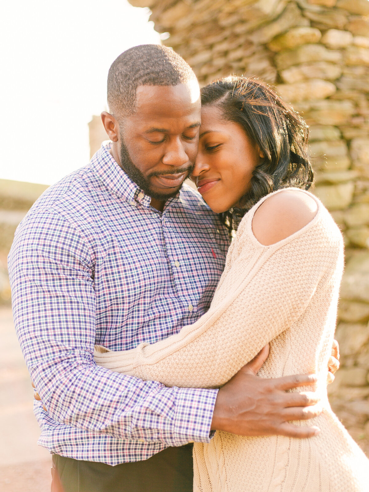 Black couple hugs each other during their engagement session.
