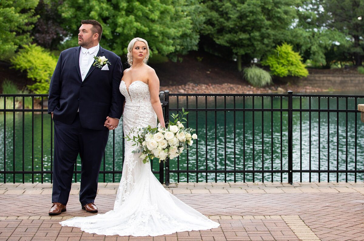 Bride and groom pose for portrait at their waterfront wedding