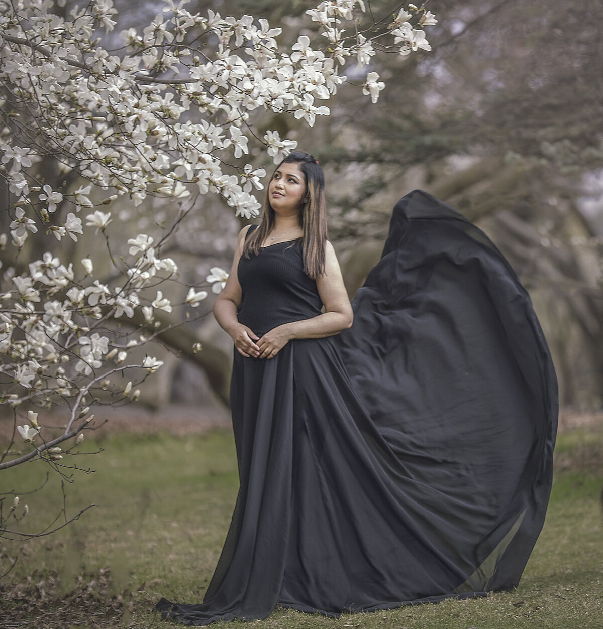 young mom with flowing dress during her spring photography session in Ottawa Ontario in the magnolias