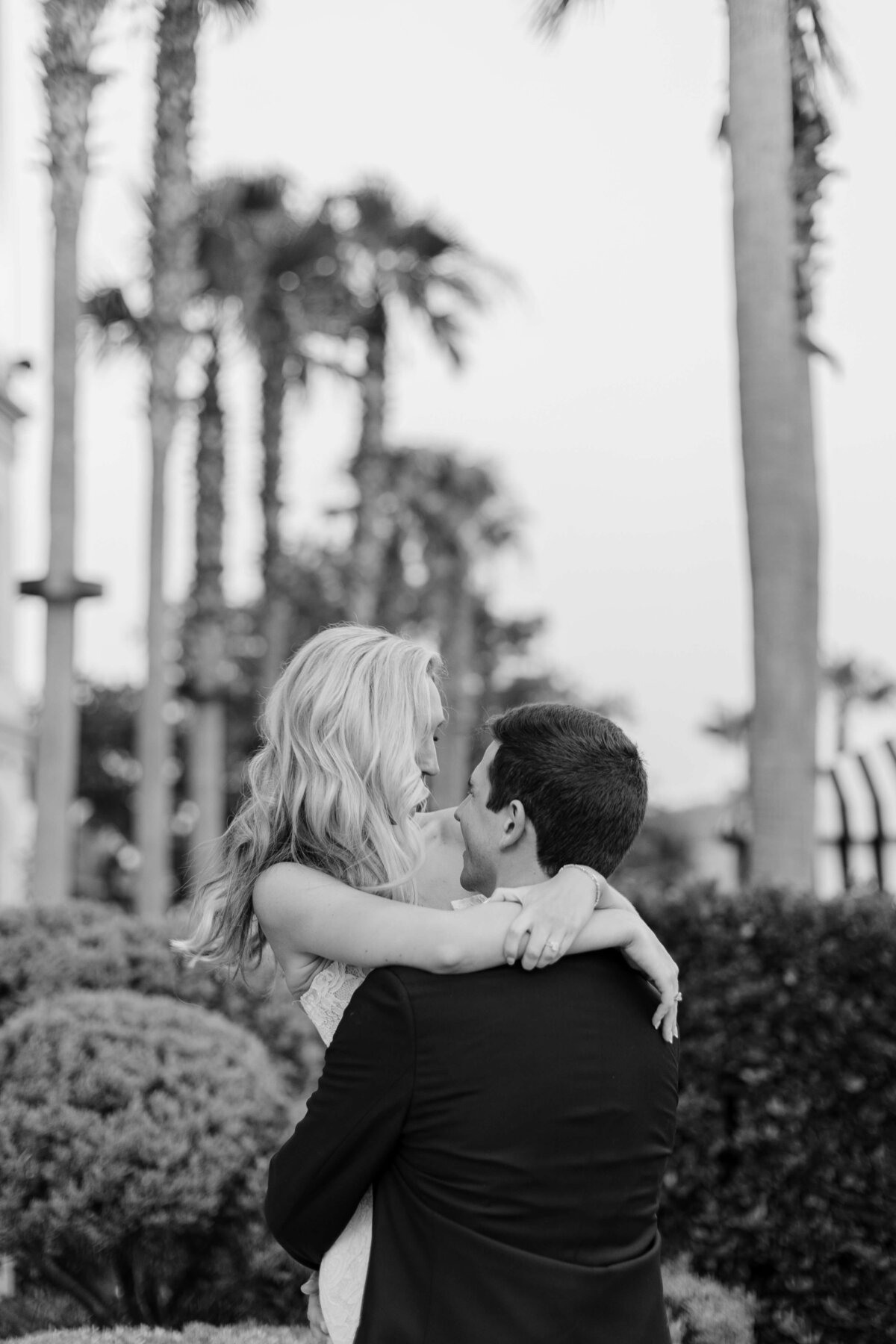 A groom holds his bride in his arms.