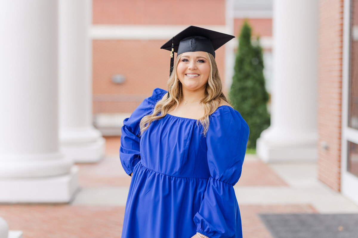 senior wearing a blue dress and graduation cap
