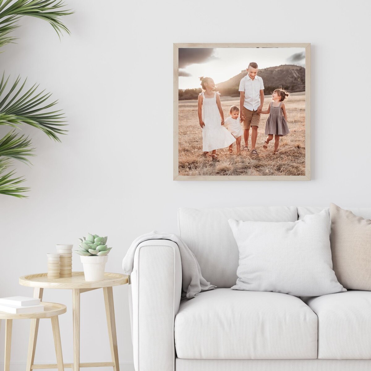 framed family portrait hung on white wall near couch and greenery by Denver photographer Alyssum Hutchison