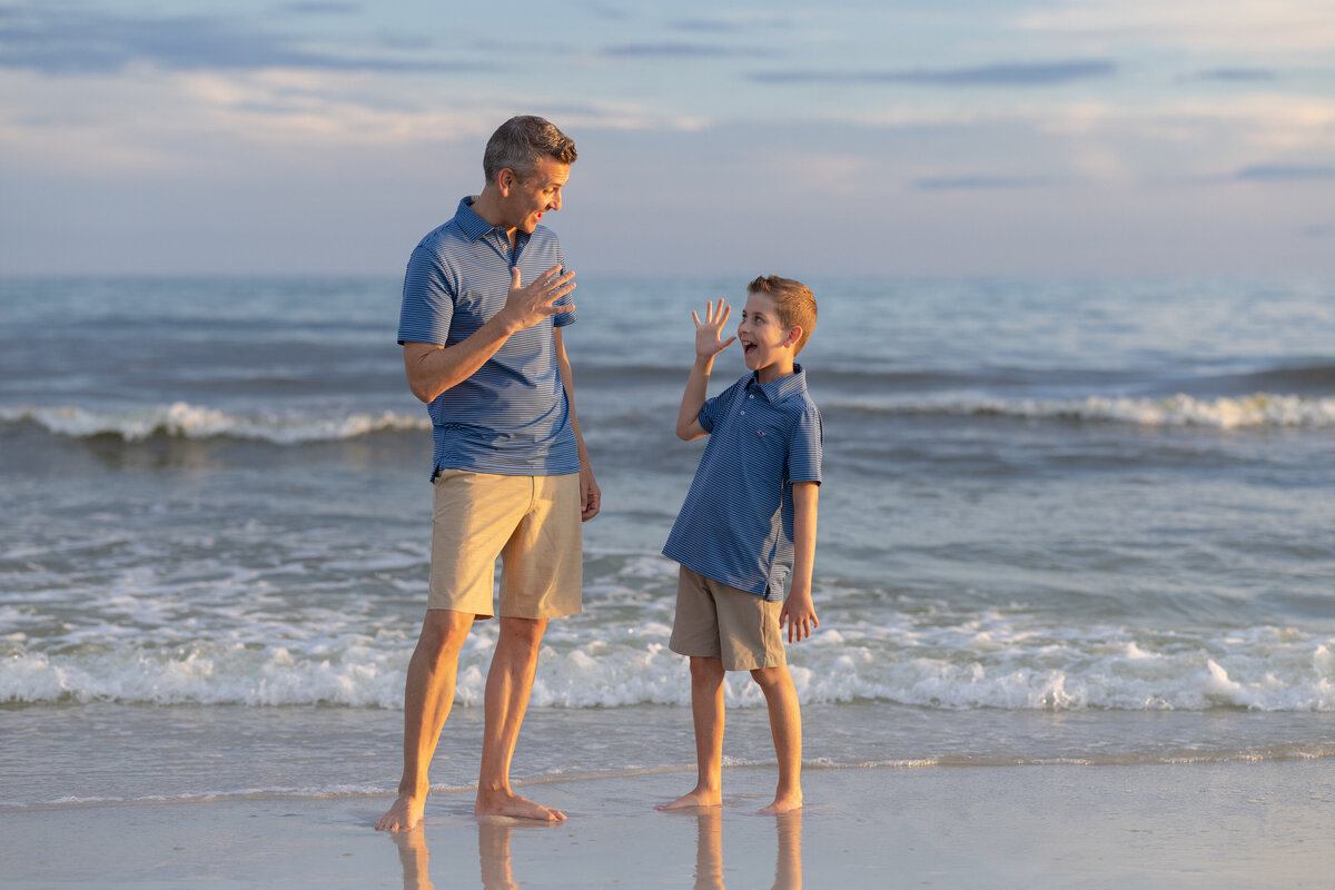 In Rosemary Beach a father and son high fiving at the beach