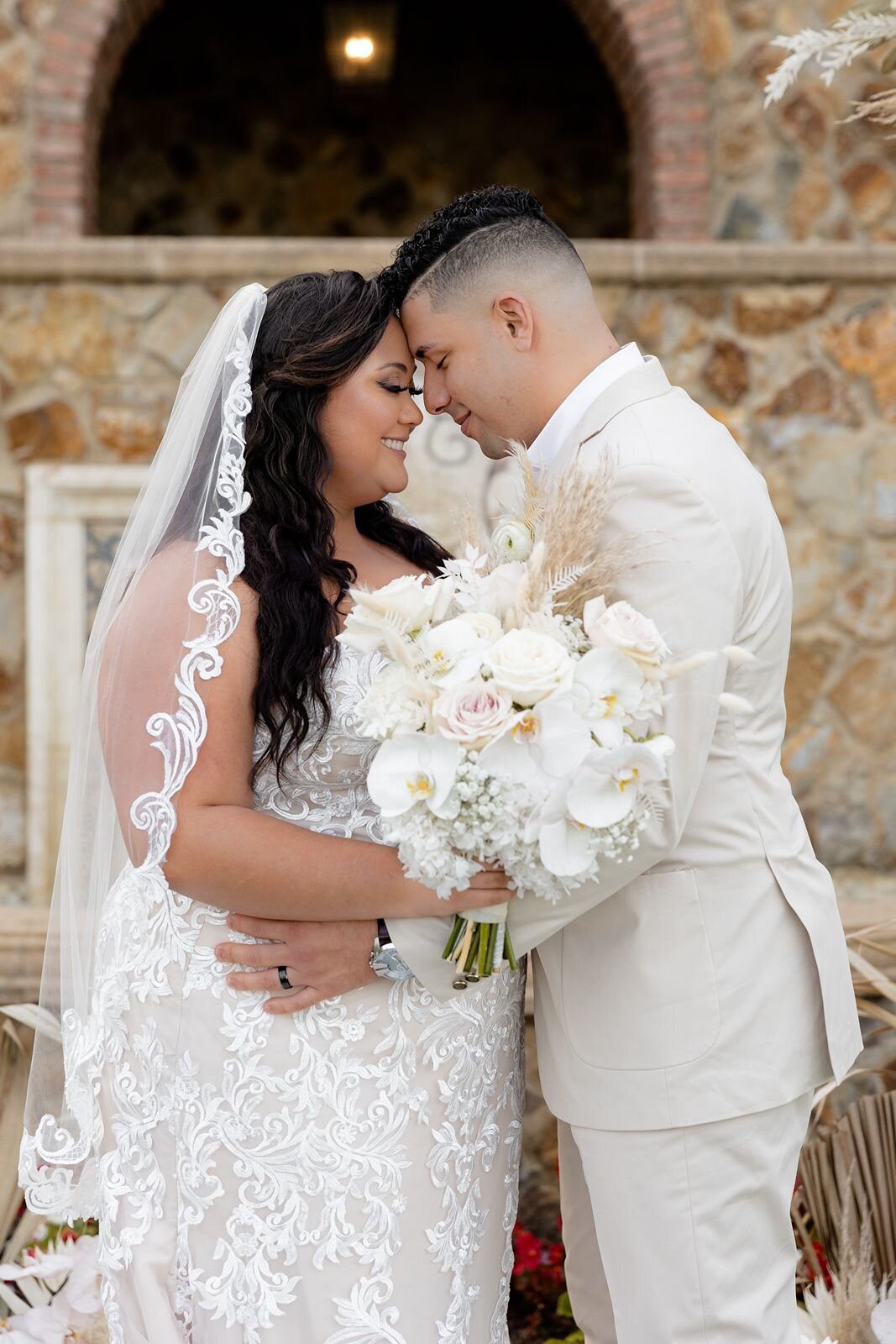 Bride with groom touching foreheads in-front  of stairs at Bella Collina in Montverde, Fl