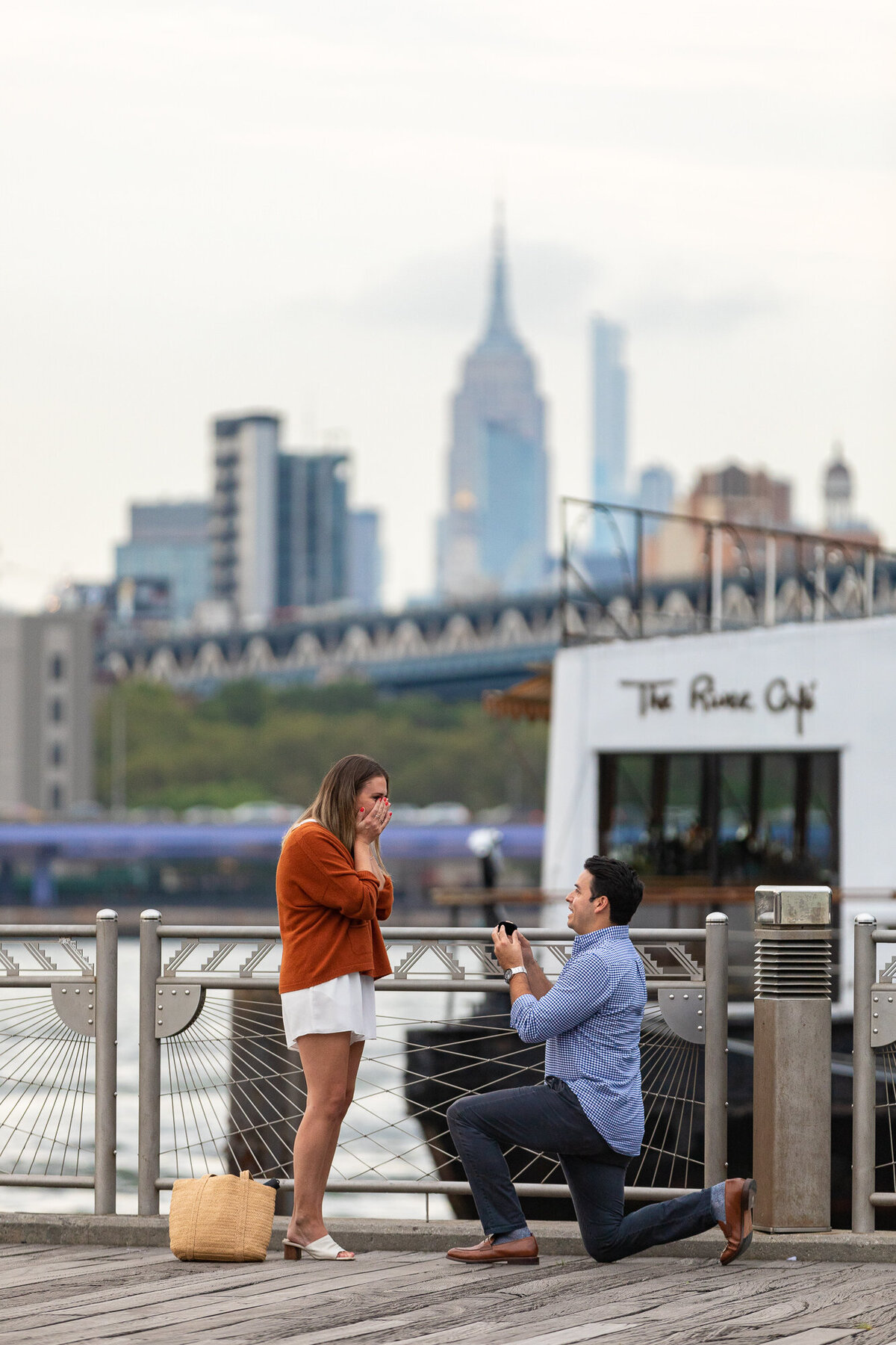 A person kneeling down and proposing to their partner.
