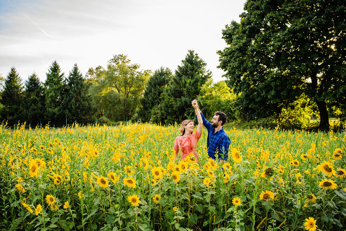 engaged couple dancing in sunflower field vermont