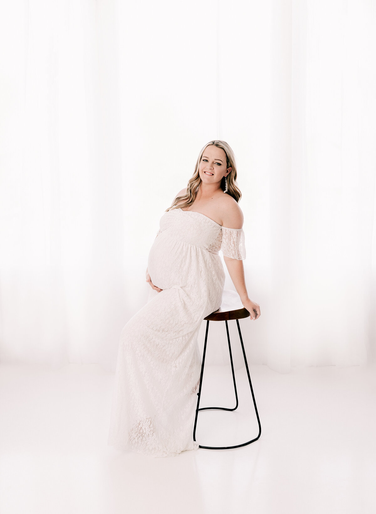 Expectant mom in a bright white maternity photo.