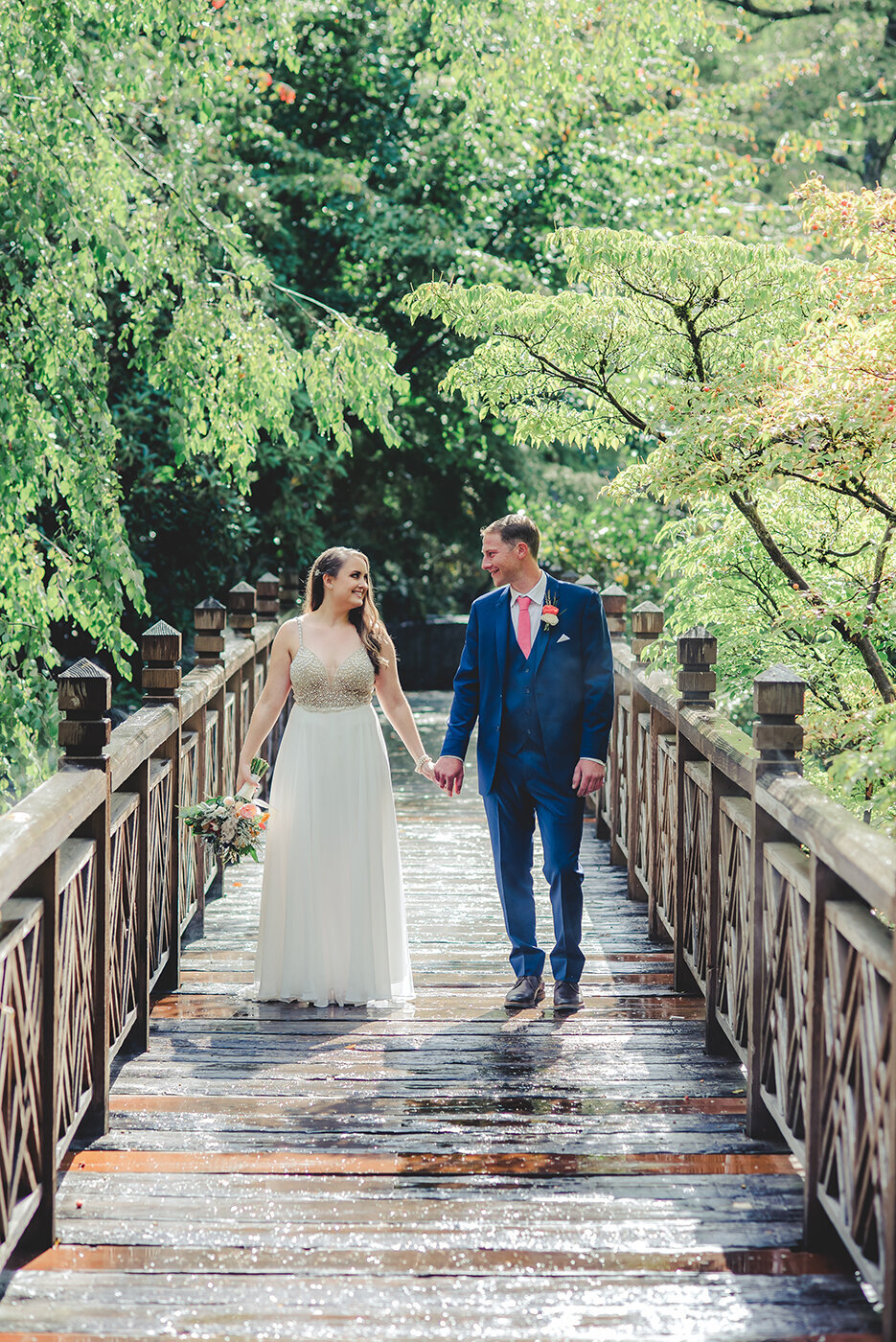 bride and groom standing on bridge