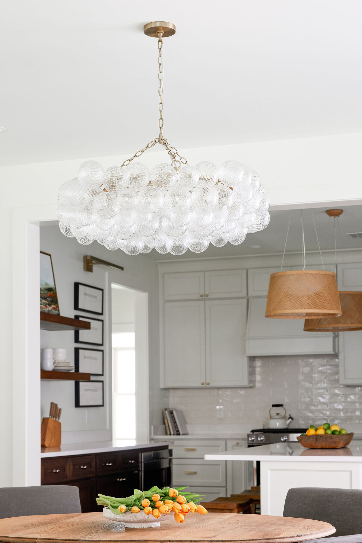 cocoloba homes cockrell ave hanging light fixture with orange tulips on the dining room table