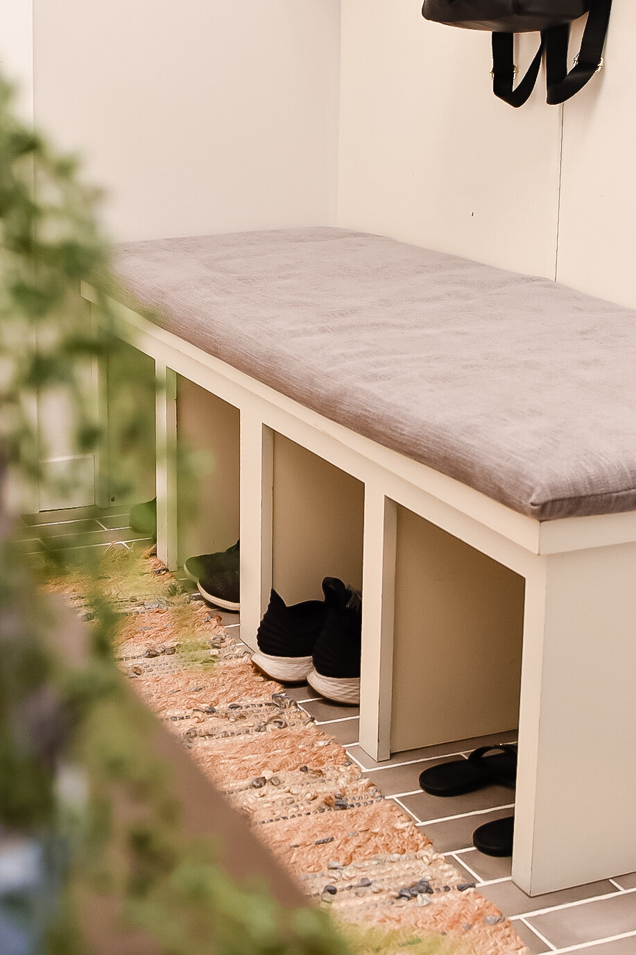 An entryway bench hides shoes in cubby holes