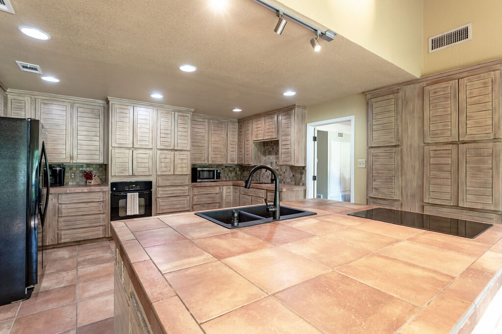 Spacious kitchen with large island and plenty of counter space in this 5-bedroom, 4-bathroom vacation rental house for 16+ guests with pool, free wifi, guesthouse and game room just 20 minutes away from downtown Waco, TX.
