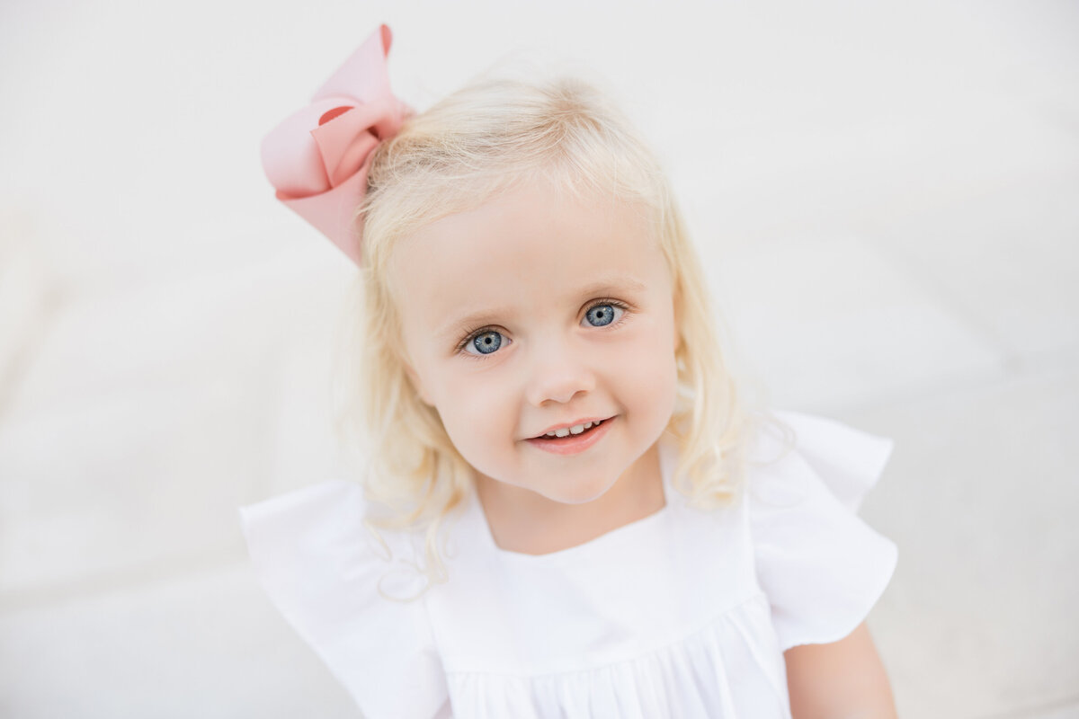 A small blonde haired girl smiling