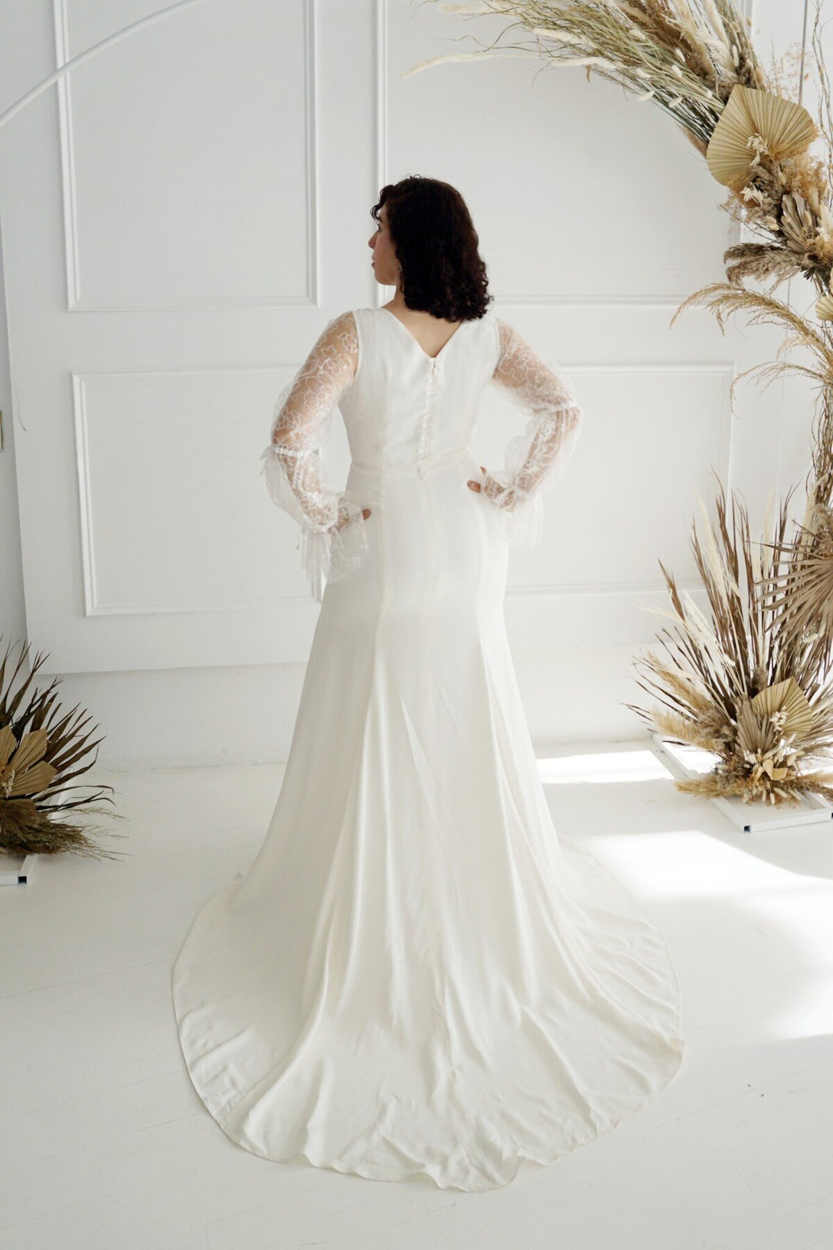 The back of the Harlow style is accented with a column of small bows that line the zipper from the v-back to the waist.