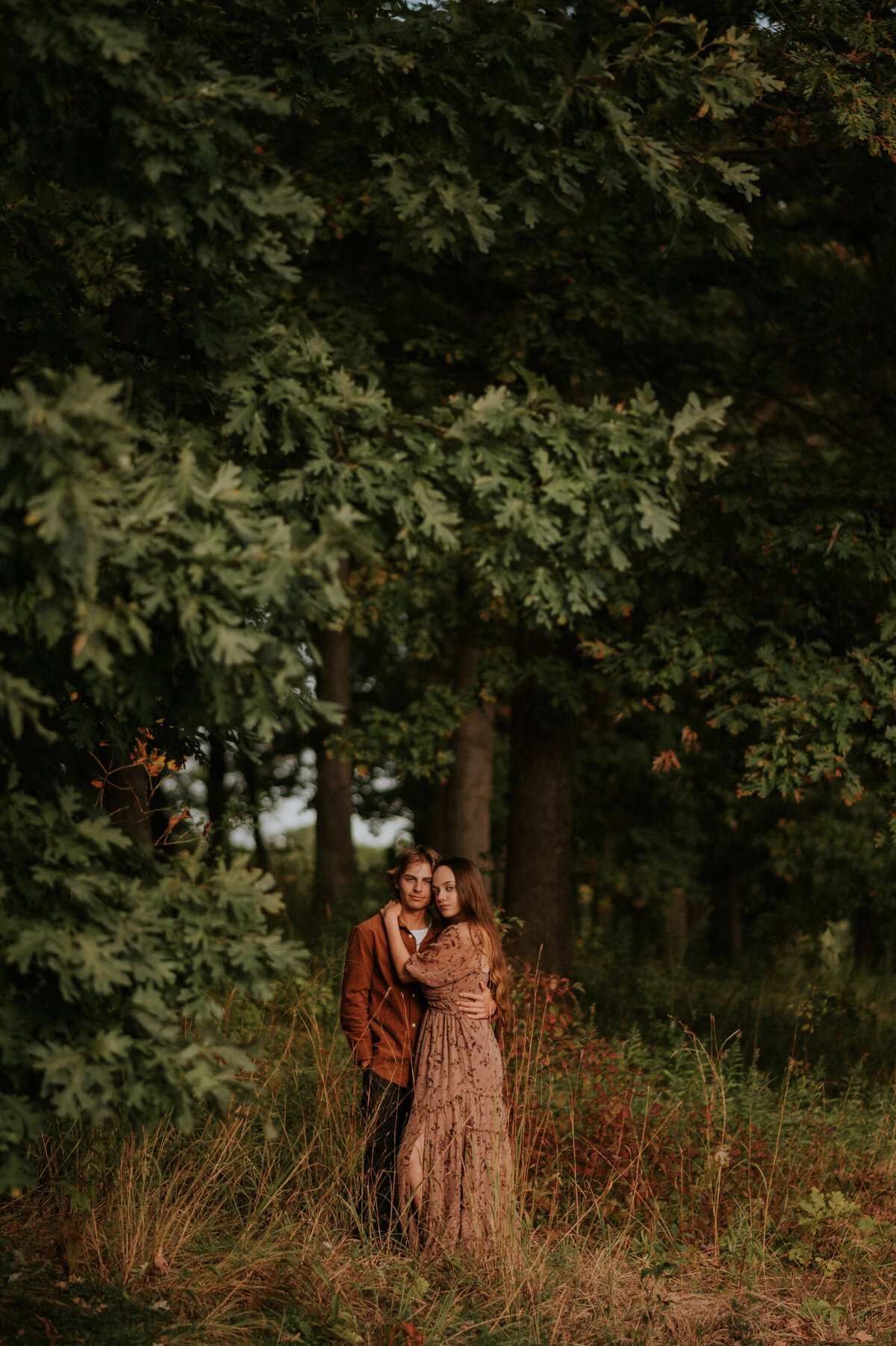 teenage couple standing in the woods in New Brighton, MN holding each other lovingly