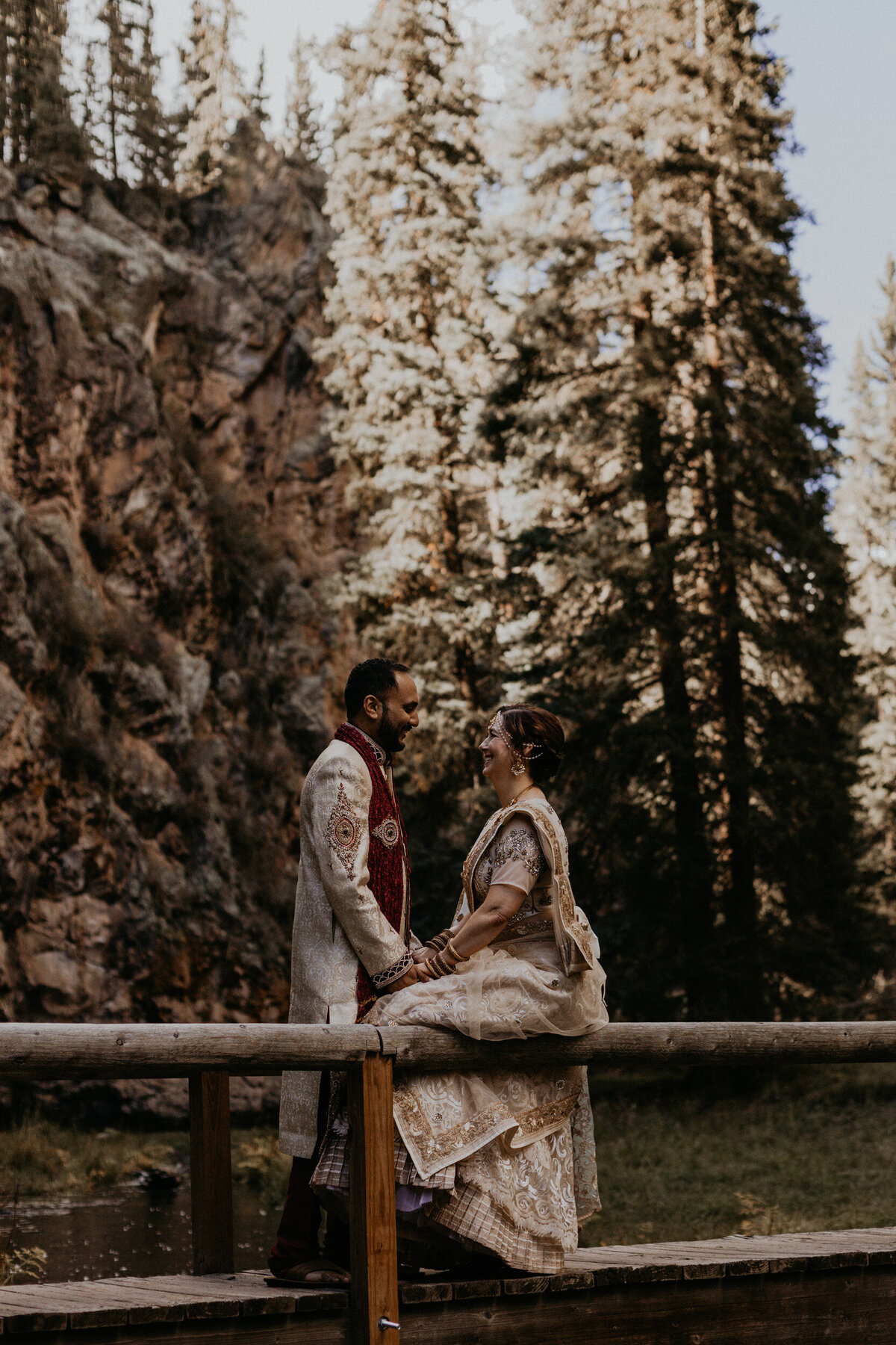 bride and groom in Indian attire on a bridge