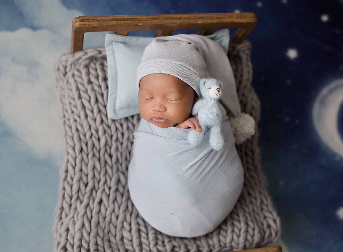baby boy, sleepy hat, blue background, with moons and stars