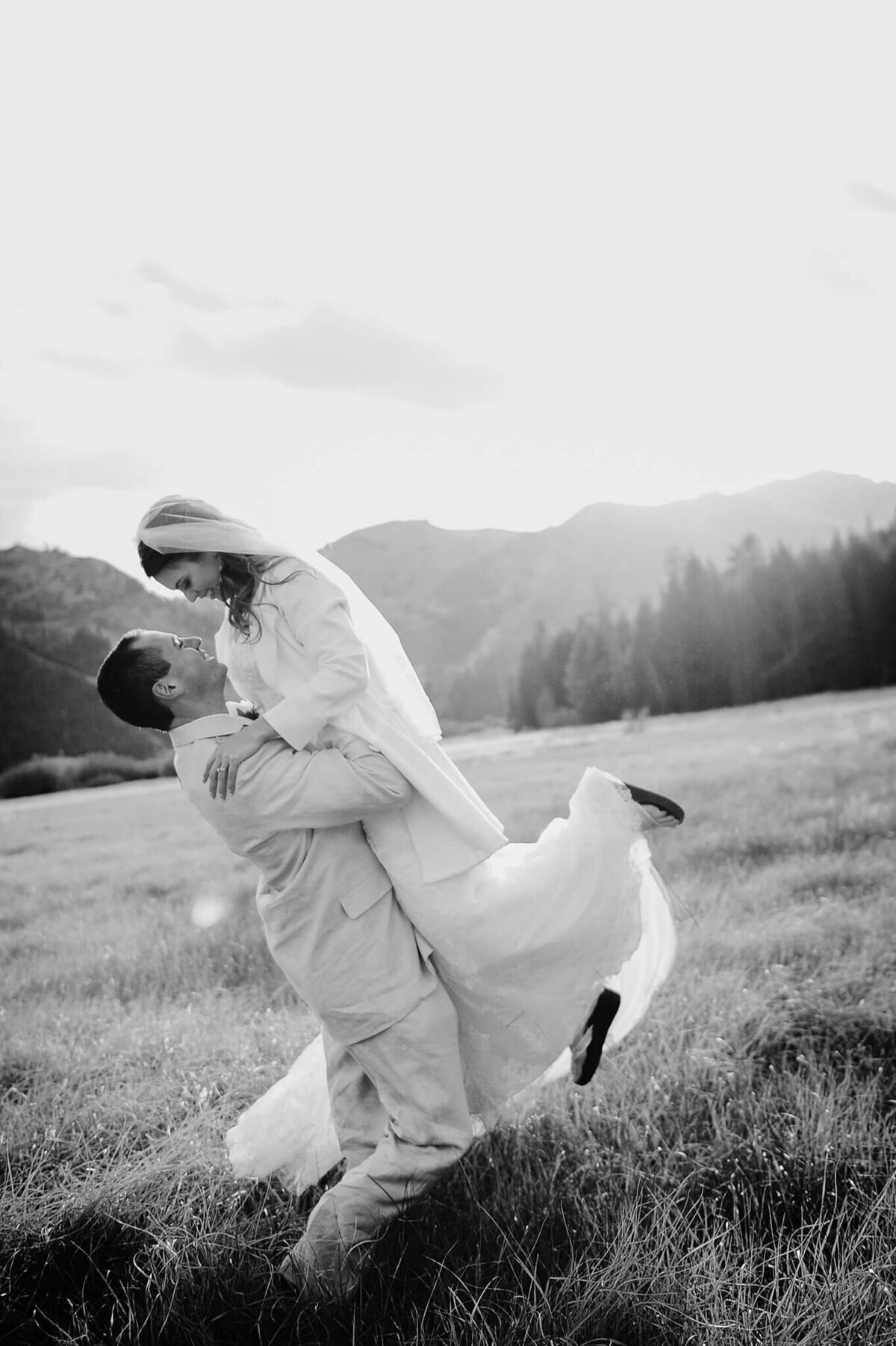 groom lifting his bride in Palisades tahoe portrait in black and white