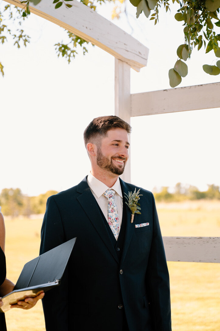 groom smiling at the altar during wedding ceremony