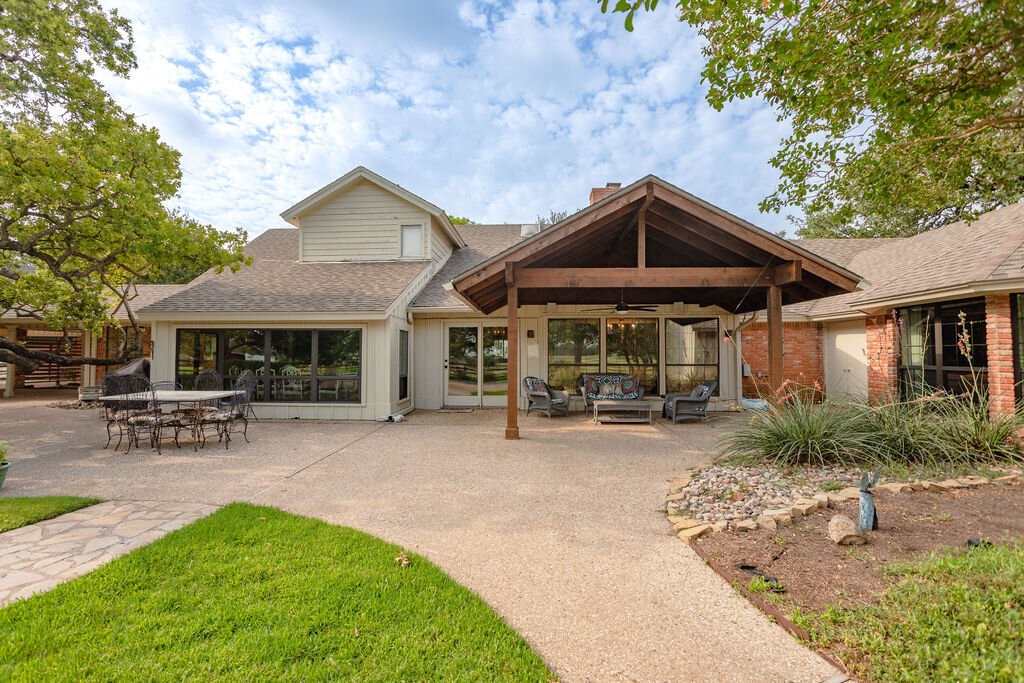 Spacious backyard with plenty of patio seating at this 5-bedroom, 4-bathroom vacation rental house for 16+ guests with pool, free wifi, guesthouse and game room just 20 minutes away from downtown Waco, TX.