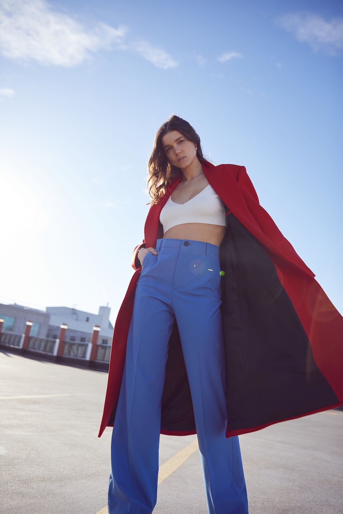 Picture of woman on rooftop in blue pants and red coat