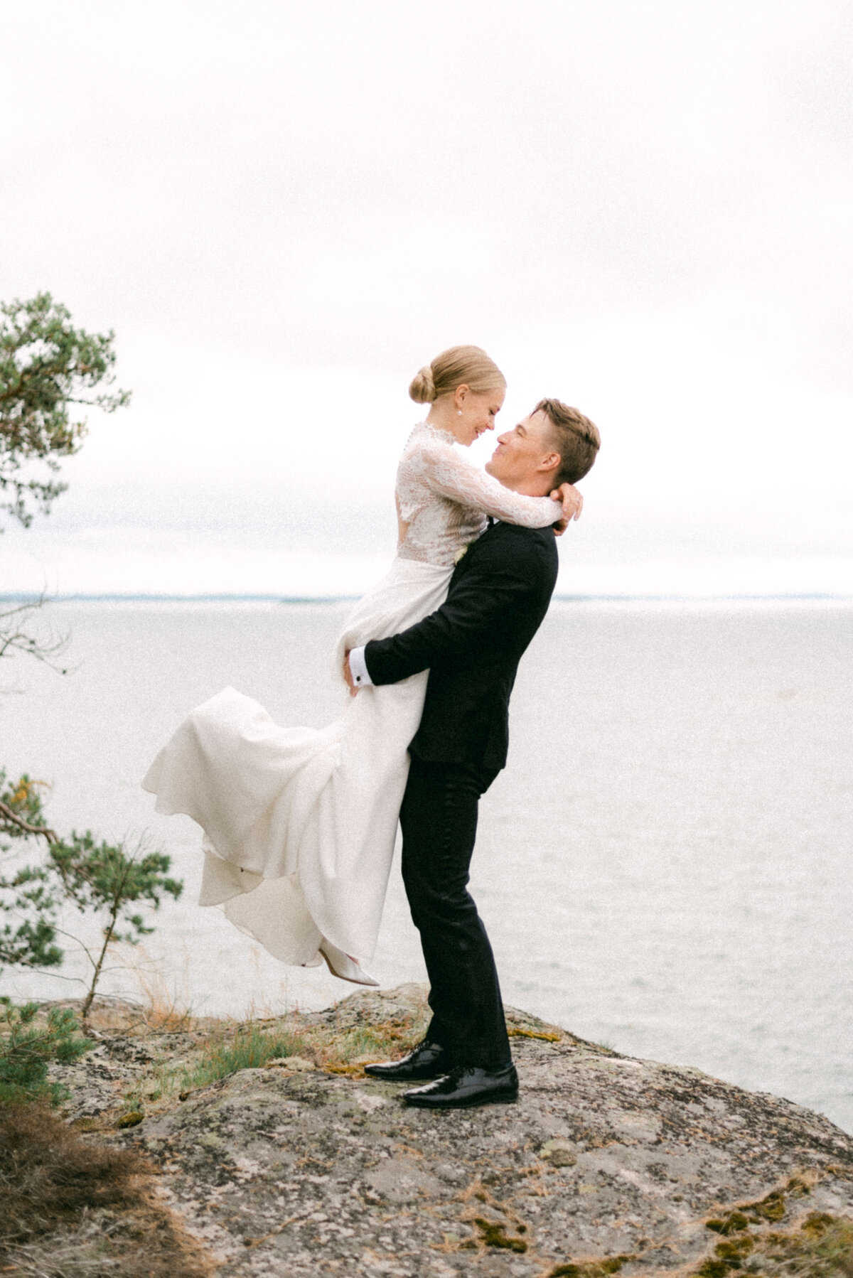 The groom is lifting the bride in a romantic wedding photograph by photographer Hannika Gabrielsson.