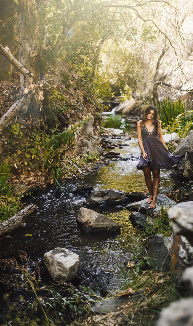 girl in free people dress in a  shallow stream
