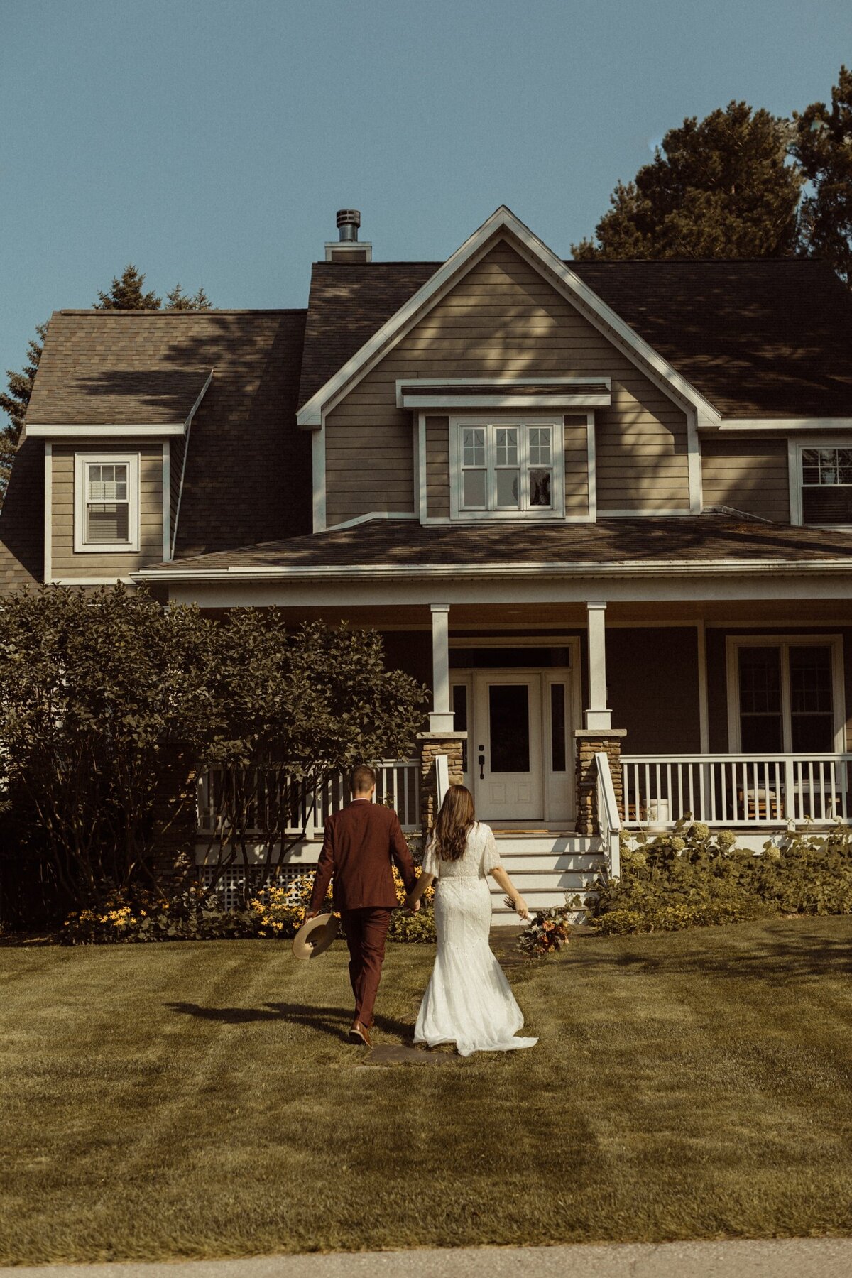 A bride and groom walking into their Michigan Airbnb for their wedding