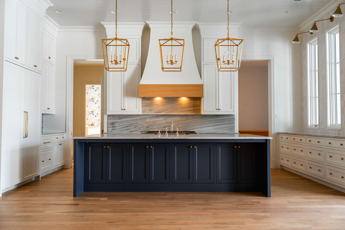 Upscale kitchen with navy island in custom home
