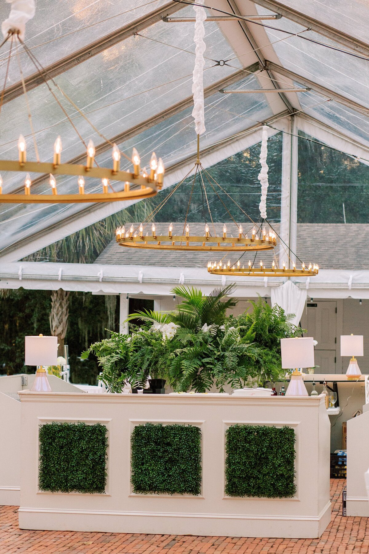 luxe tented wedding reception and greenery covered bar