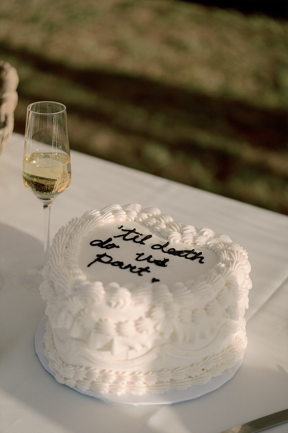 Heart-shaped all-white wedding cake at an elegant summer wedding in Jackson, WY
