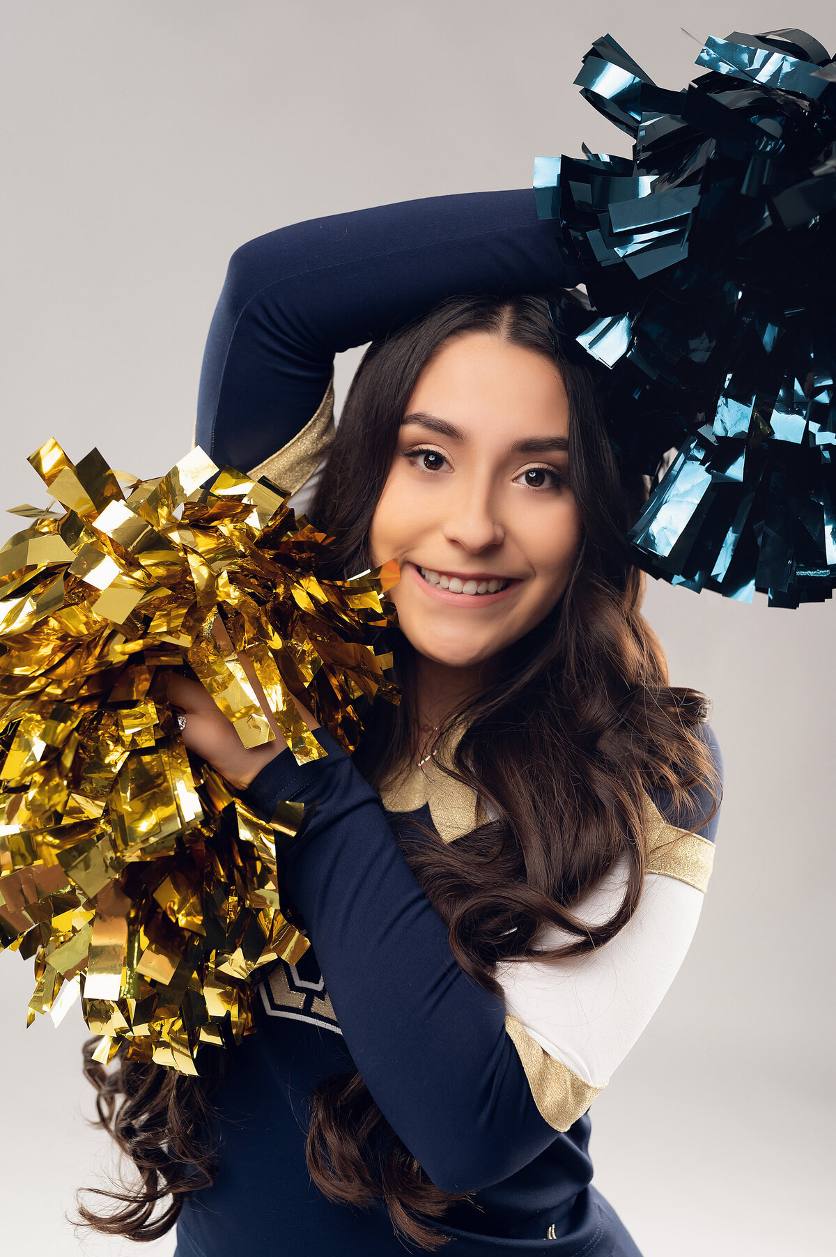 A senior cheerleader from Kettle Moraine High School poses in our Waukesha studio wearing her uniform and holding her pompoms.