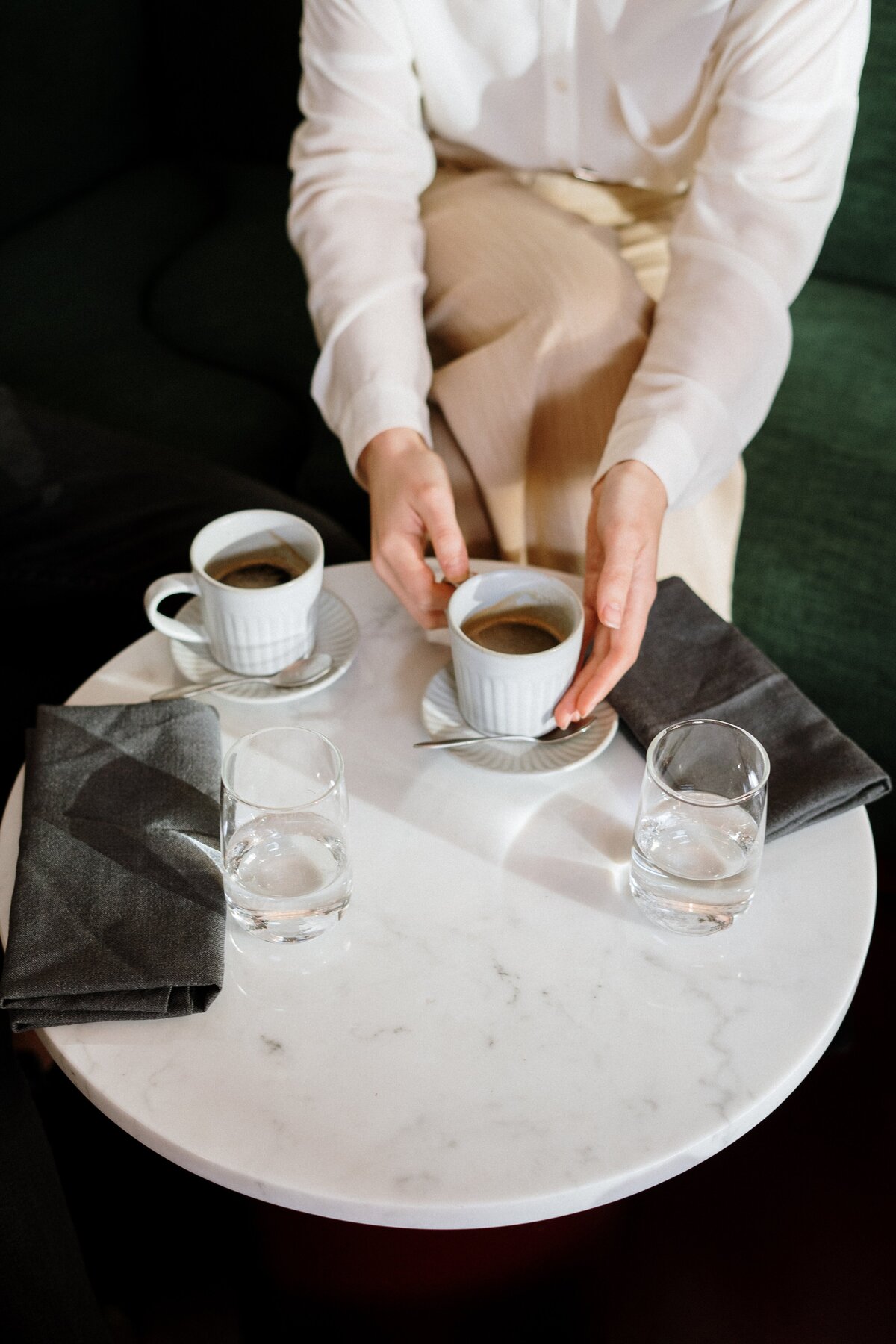 person-holding-white-ceramic-cup-on-white-table-4255416