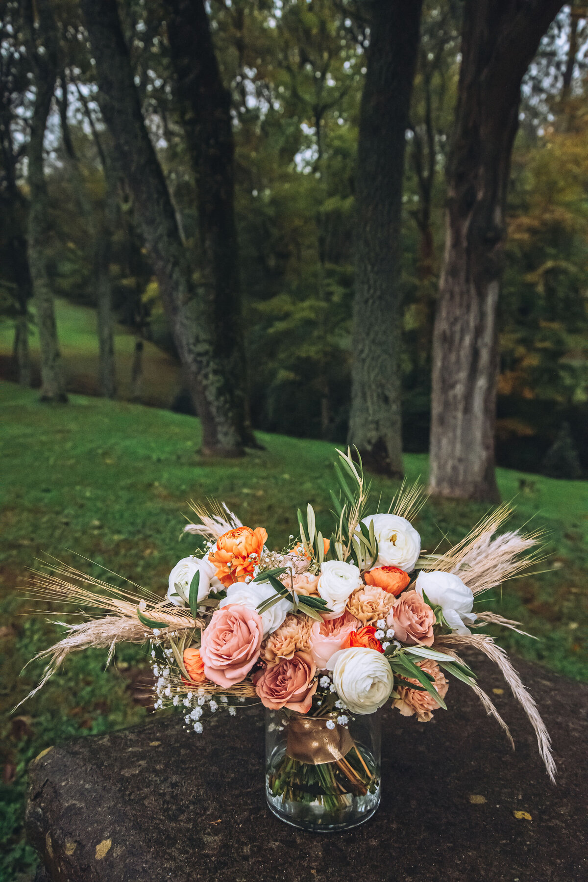 Bridal bouquet with peach, orange, white flowers accented with pampas and wheat
