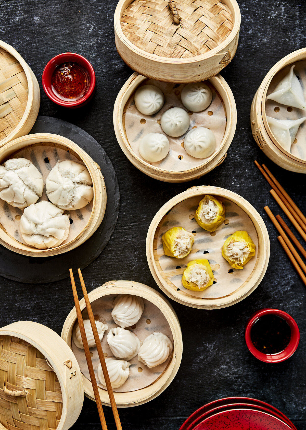 A few steaming baskets with various dumplings in them.